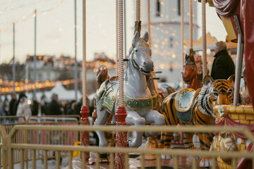 Christmas carousel with colorful animal figures at Cathedral Square in Vilnius, Lithuania. Festive amusement ride and holiday lights create a cheerful winter atmosphere. © MNStudio