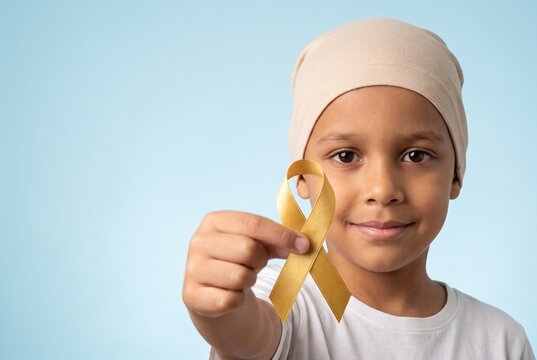  Retrato de um menino brasileiro com c&acirc;ncer usando touca e segurando um la&ccedil;o dourado. Campanha Setembro Dourado de conscientiza&ccedil;&atilde;o sobre o c&acirc;ncer infantil. Espa&ccedil;o para texto