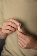 Close-up of hands collecting and preparing a biological sample for genetic analysis at home. The...