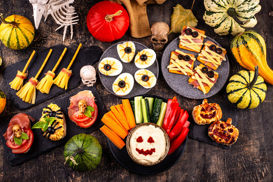 Halloween appetizers with pumpkin hummus deviled eggs and mummy snacks