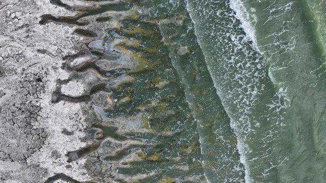 An aerial view of the white, salty soil exposed as the water level in Lake Burdur receded due to drought, and the waves crashing against the shore.