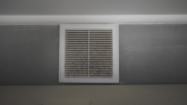 Grimy ventilation duct cover on a wall full of dust, dirt, and mold. Urgent need for HVAC service, maintenance, and cleaning