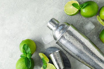 Ingredients for mojito, shaker and jigger on light grey table, flat lay. Space for text