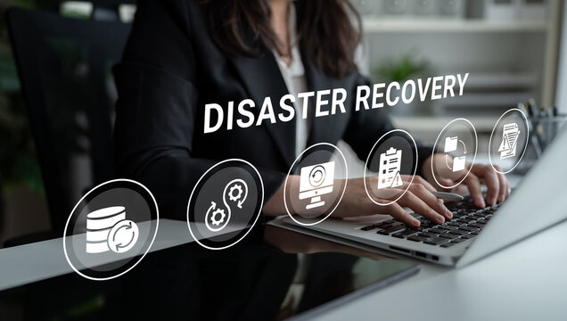 A business professional focuses on disaster recovery planning, showcasing essential icons for data backup and recovery strategies in a modern office environment. Ledger