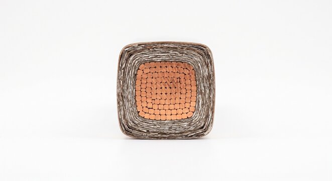 Cut end of a generator stator coil bar. Complex rectangular bundle of pure copper strands with micaceous epoxy insulation. High-voltage alternator hardware isolated on a white background.