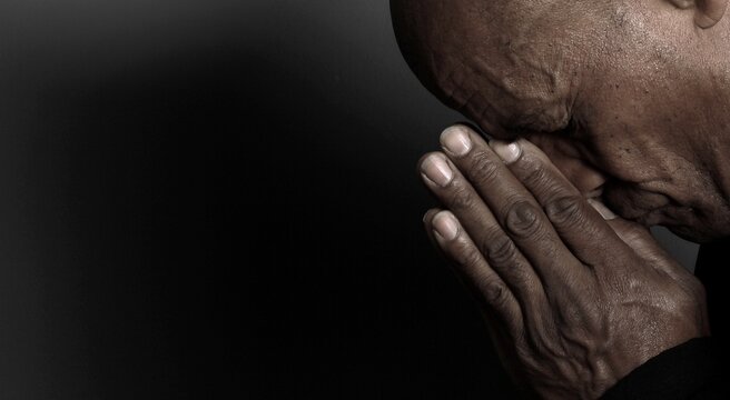 A serene portrait of a man praying with hands together in deep prayer that perfectly captures themes of faith, hope, mindfulness, and inner peace stock image stock photo