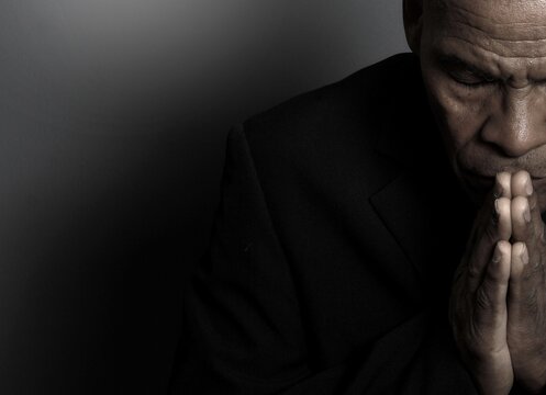 A serene portrait of a man praying with hands together in deep prayer that perfectly captures themes of faith, hope, mindfulness, and inner peace stock image stock photo