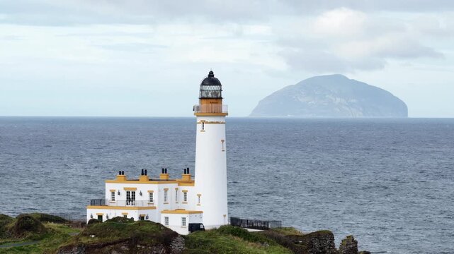 Turnberry Lighthouse on the Ayrshire coast of Scotland, filmed by drone with Ailsa Craig rising from the Firth of Clyde in the distance.