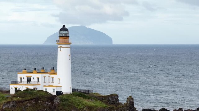 Turnberry Lighthouse on the Ayrshire coast of Scotland, filmed by drone with Ailsa Craig rising from the Firth of Clyde in the distance.