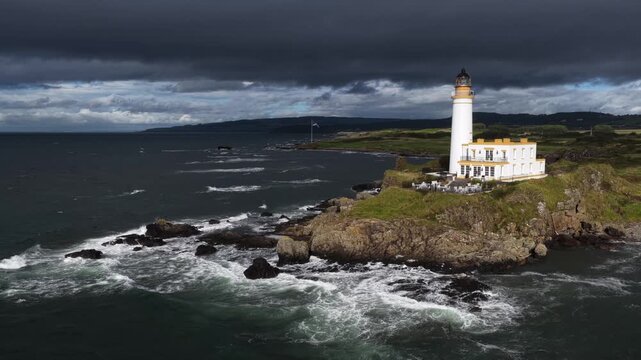 Turnberry Lighthouse on the Ayrshire coast of Scotland, filmed by drone with Ailsa Craig rising from the Firth of Clyde in the distance.