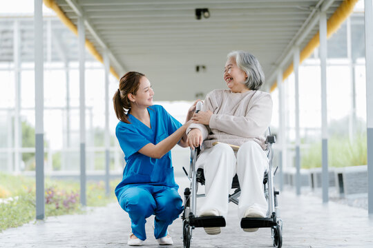 Caring nurse providing elderly health care support for happy senior patient in wheelchair creating feeling of joyful medical assistance