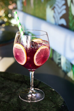 raspberry infused cocktail with blueberry and lime served in a wine glass