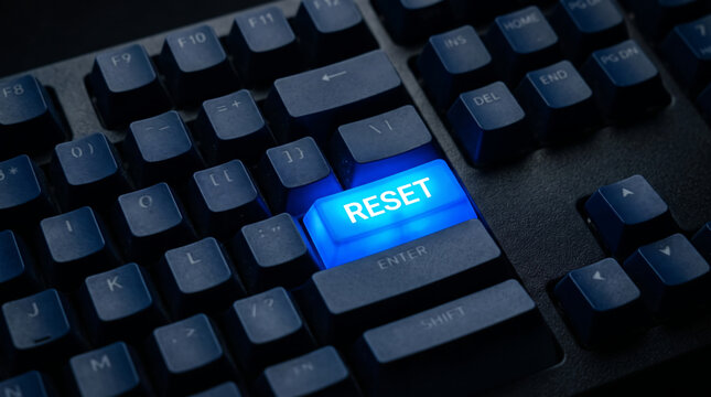 Glowing blue reset button on a black computer keyboard, illuminated reset key for system recovery, digital restart and troubleshooting concept