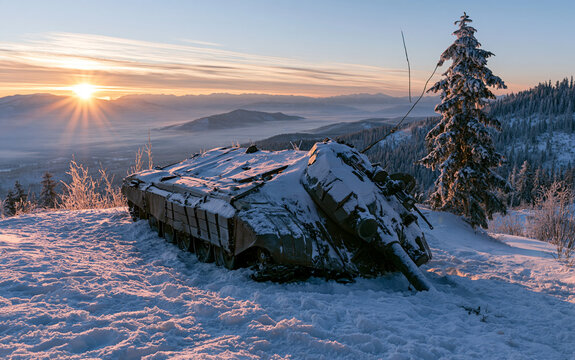 Overturned military tank on snowy mountain at sunset with snow and tree, landscape, war concept.