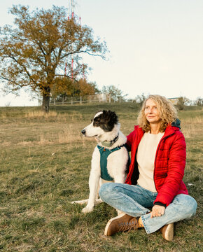 happy woman with dog enjoying autumn outdoors