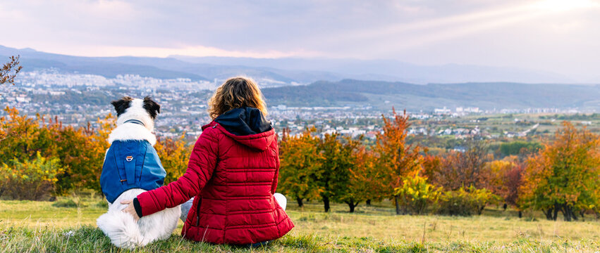 happy woman with dog enjoying autumn outdoors