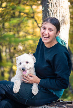 happy woman with dog enjoying autumn outdoors