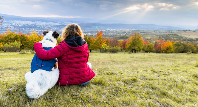 happy woman with dog enjoying autumn outdoors