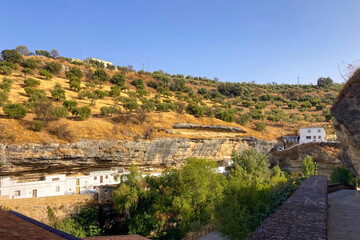 Obraz premium Unique whitewashed village built into dramatic rock formations, offers one of Andalusia’s most picturesque sights in Setenil de las Bodegas, Spain