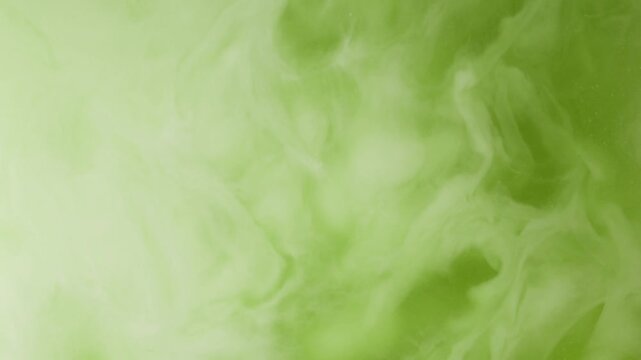 Macro view of coconut milk blending with green matcha tea, forming wispy white swirls and fluid patterns. Vegan matcha latte preparation with plant based milk, creamy textures.