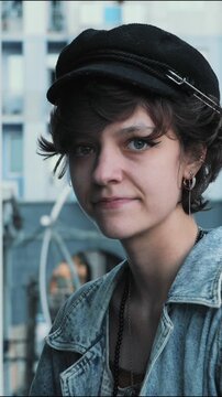 Stylish young woman turns to camera, sticks out tongue and smiles, playful portrait of confident Gen Z self expression and authentic personality, Vertical Video.