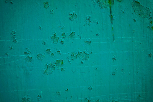 Distressed turquoise wall with peeling paint texture as background