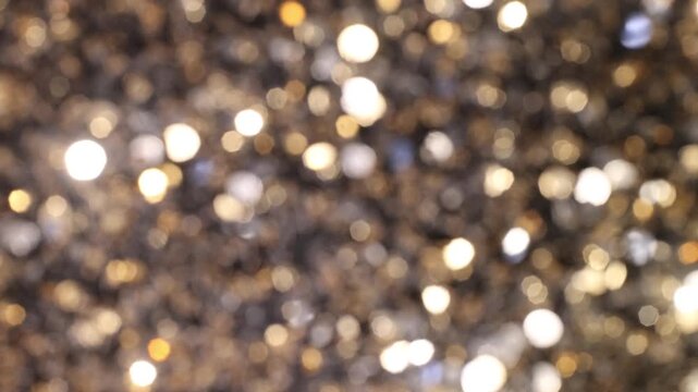 Golden bokeh lights creating a sparkling effect on a neutral background, decorative backdrop. 
