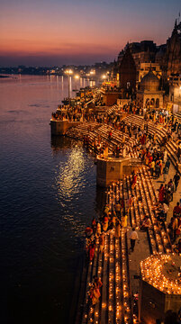 Riverbank illuminated by thousands of small lamps during the evening festivities of a traditional holiday.