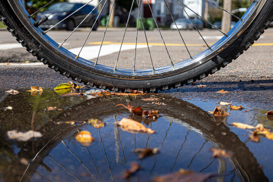 Reflection of bicycle wheel in a puddle on the street