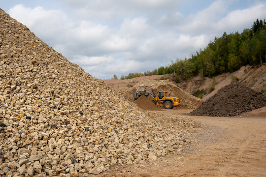 Large pile of crushed stone aggregate with wheel loader working in a quarry