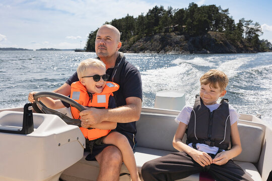 Father and two sons boating in Baltic sea