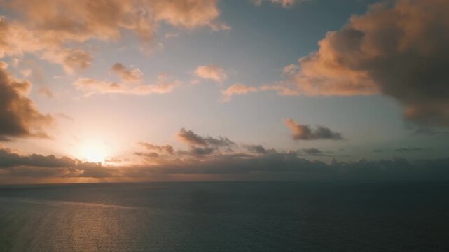 Golden sun dipping into a hazy ocean horizon at dusk