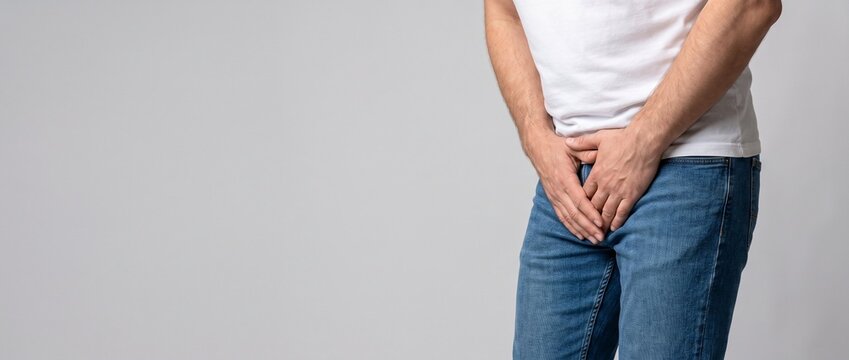 Homem irreconhec&iacute;vel segurando a virilha. Conceito de dor urol&oacute;gica, c&acirc;ncer de pr&oacute;stata, IST ou incontin&ecirc;ncia urin&aacute;ria. Banner de sa&uacute;de masculina com espa&ccedil;o para texto