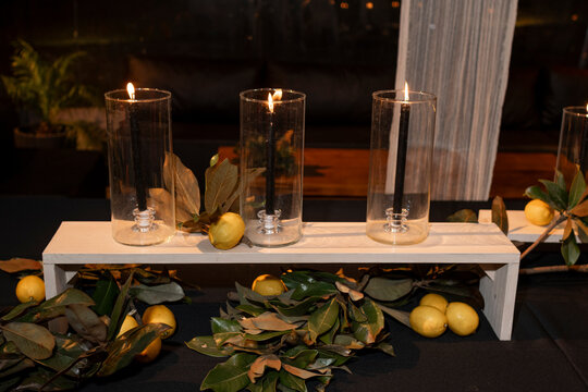 Mesa decorada en fiesta con candelas en frascos de vidrio