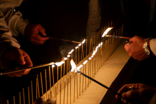Manos encendiendo candelas encendidas en pastel de cumplea&ntilde;os