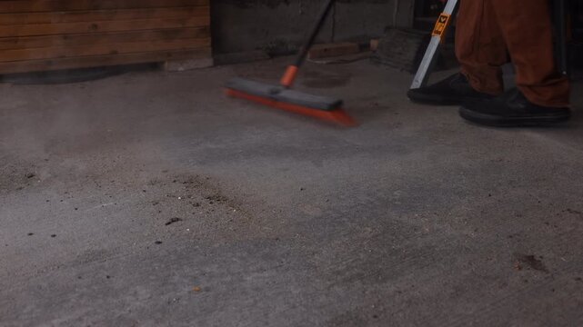 Shop broom sweeping up dirt on floor