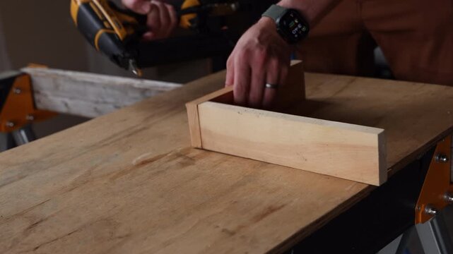 pneumatic nail gun driving nails into two pieces of wood wit satisfying thud sound