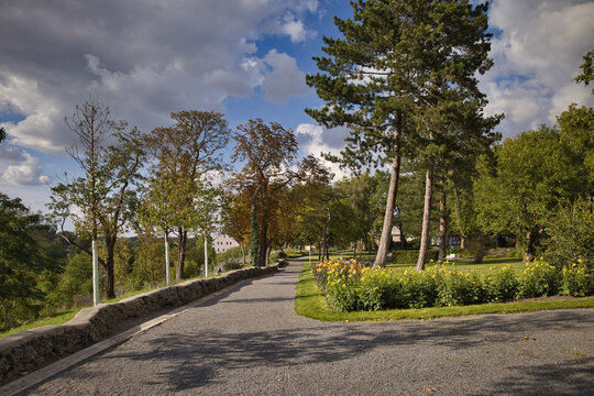 Idyllischer und begr&uuml;nter Kurpark mit gepflegten Rasenfl&auml;chen, B&auml;umen, Blumenbeeten und Spazierwegen im Sonnenschein im Saalekreis, Sachsen-Anhalt, Deutschland