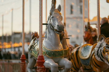 Christmas carousel with colorful animal figures at Cathedral Square in Vilnius, Lithuania. Festive amusement ride and holiday lights create a cheerful winter atmosphere. © MNStudio