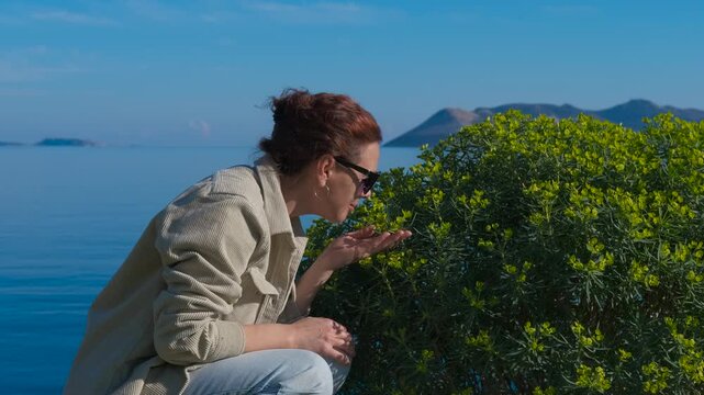 Pollen allergy. A traveler inhales the floral scent and feels allergic to the Mediterranean coast and the vibrant vegetation around her.