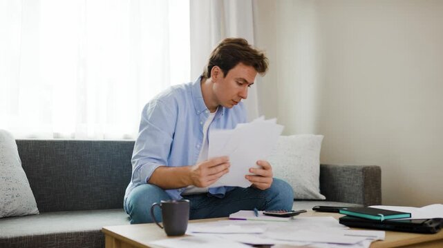 stressed man dealing with financial pressure, calculating unpaid overdue utility bills and household expenses during an energy crisis with rising inflation. High quality 4k footage