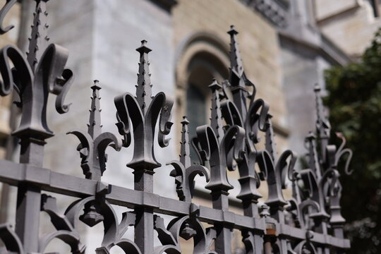 D&eacute;tails d'une grille en fer forg&eacute; devant une architecture religieuse historique