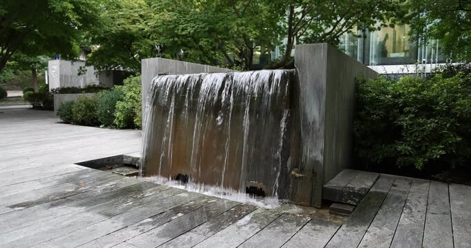Fontaine contemporaine et cascade dans un espace urbain arbor&eacute;