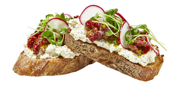 Isolated delicious bruschetta with creamy spread, sun-dried tomatoes, radishes, and microgreens