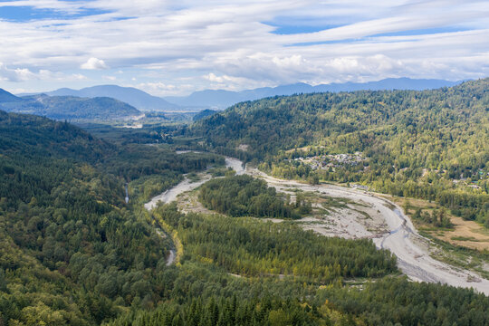 Aerial View of River Valley and Forested Hills With Mountains Near Chilliwack, BC, Canada