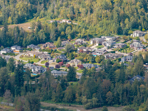 Aerial View Of Suburban Neighborhood Homes Nestled Against Forested Hillside In Chilliwack BC