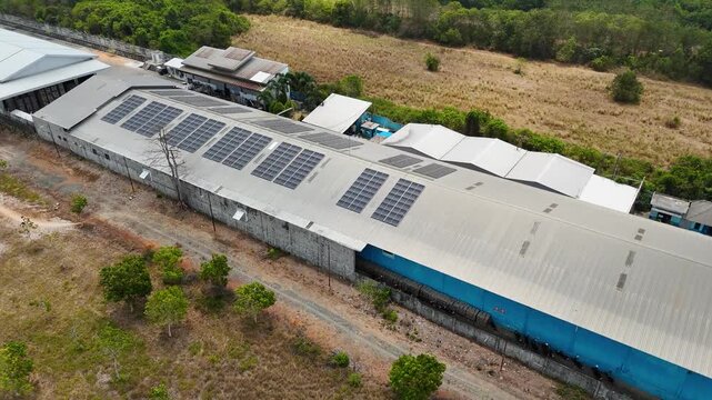 Industrial warehouse facility with extensive solar panel array on a metal roof in Indonesia