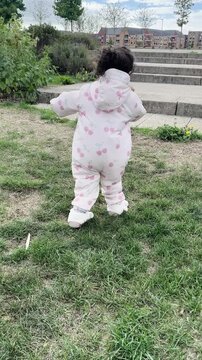 Toddler Baby Running on Grass Towards Playground Stairs