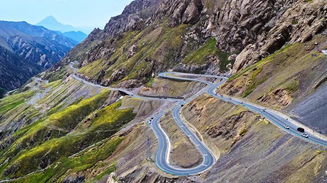Aerial drone view of a steep winding mountain highway with dramatic switchback turns on the Duku Highway in Xinjiang, China