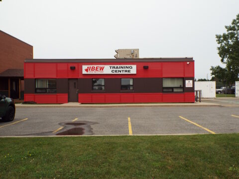  Gloucester, Ontario, Canada &ndash; July 12, 2026: The exterior of the red and brown "IBEW Training Centre" building stands behind an empty asphalt parking lot at 5500 Canotek Road. 